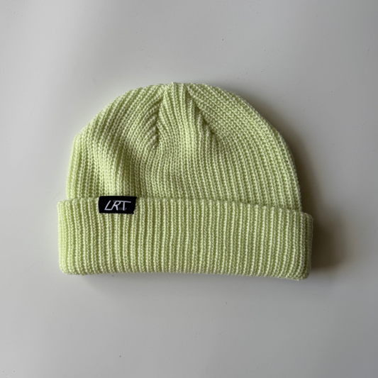 Light green beanie with a black label on a gray background